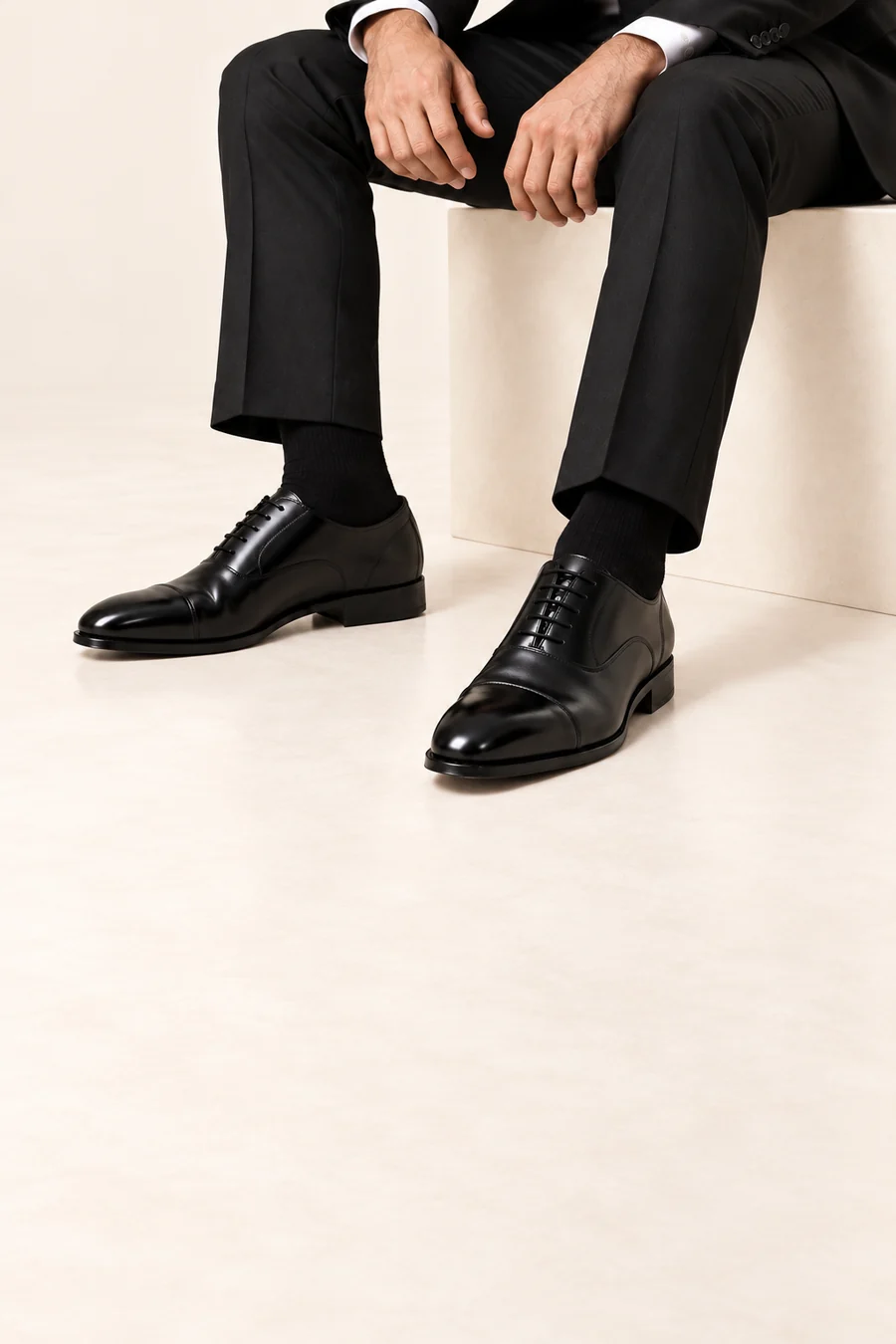 Conceptual model wearing polished black Oxford shoes